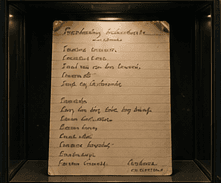 Handwritten recipe card for Fasolka po bretońsku, lit in a display case